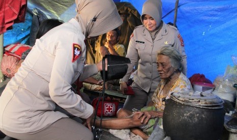 Dua orang tim medis dari Brimob Polda Sulawesi Tenggara memeriksa kesehatan lansia korban banjir bandang di tenda pengungsian di Kelurahan Wanggu, Kendari, Sulawesi Tenggara, Senin (10/6/2019).