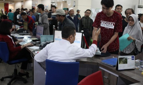 Petugas melayani warga yang mengurus dokumen kependudukan di Mall Pelayanan Publik Surabaya, Jawa Timur.  Berdasarkan survei Teropong Jatim, 95,4 persen masyarakat puas terhadap pelayanan surat-surat kependudukan di Surabaya.