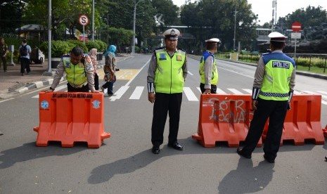 Polisi lalu lintas berjaga di ujung Jalan Medan Merdeka Barat yang ditutup di Jakarta, Jumat (14/6/2019). 