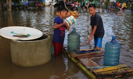 Warga mengambil air di sumur yang telah bercampur air banjir di Desa Wanuamandala, Konawe, Sulawesi Tenggara, Sabtu (15/6/2019).