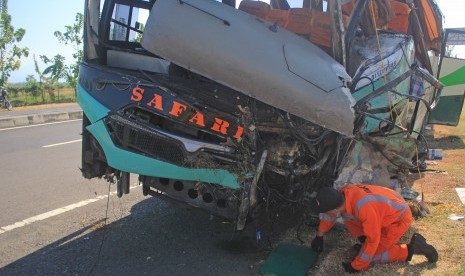 Petugas Komite Nasional Keselamatan Transportasi (KNKT) melakukan identifikasi bus Safari Lux Salatiga yang mengalami kecelakaan di tol Cipali KM 151, Majalengka, Jawa Barat, Senin (17/6/2019). 