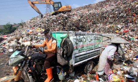 Pekerja membongkar muat sampah di Tempat Pembuangan Akhir (TPA) Sampah Cipayung, Depok, Jawa Barat.