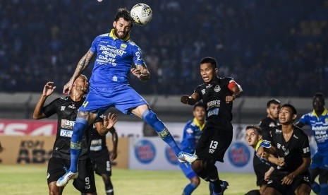 Pesepak bola Persib Bandung Bojan Malisic (kedua kiri) menyundul bola ke arah gawang Tira Persikabo saat pertandingan Sepak Bola Liga 1 2019 di Stadion Si Jalak Harupat, Kabupaten Bandung, Jawa Barat, Selasa (18/6/2019). 