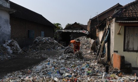 Warga memilah tumpukan sampah plastik impor di halaman rumahnya di Desa Bangun di Mojokerto, Jawa Timur, Rabu (19/6/2019). 