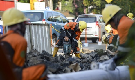 Pekerja membongkar trotoar lama di Jalan Cikini Raya depan Taman Ismail Marzuki (TIM), Jakarta, Rabu (19/6/2019).