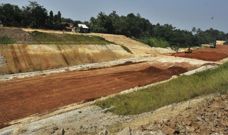 Sejumlah pekerja dengan menggunakan alat berat menyelesaikan proyek pembangunan jalan Tol Serang-Panimbang di Kampung Parongpong, Cukeusal, Serang, Banten, Jumat (21/6/2019).