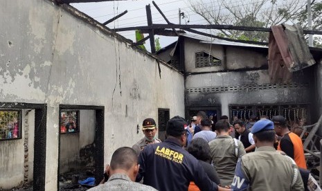 Petugas kepolisian melakukan identifikasi lokasi kebakaran pabrik korek api di Desa Sambirejo Kecamatan Binjai Kabupaten Langkat, Sumatera Utara, Jumat (21/6/2019). 