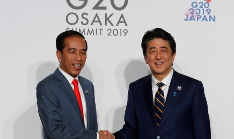 Presiden Joko Widodo (kiri) disambut PM Jepang Shinzo Abe pada KTT G20 di Osaka Jepang, Jumat (28/06/2019).