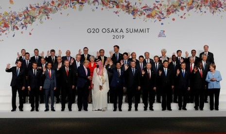 Presiden Joko Widodo (depan, tiga kiri) melambaikan tangan saat berfoto bersama para pemimpin negara-negara peserta KTT G20 di Osaka Jepang, Jumat (28/06/2019).