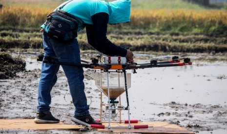 Teknisi melakukan uji coba penggunaan wahana tak berawak atau drone untuk menebar benih padi di Persawahan kawasan Krian, Sidoarjo, Jawa Timur, Sabtu (29/6/2019).