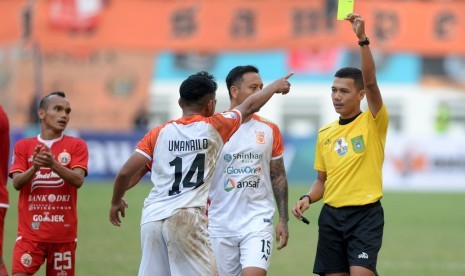 Wasit Wawan Rapiko (kanan) memberikan kartu kuning pada pesepak bola Borneo FC Abrizal Umanailo (ketiga kanan) saat melawan Persija Jakarta dalam pertandingan semifinal leg pertama Piala Indonesia di Stadion Wibawa Mukti, Cikarang, Kabupaten Bekasi, Jawa Barat, Sabtu (29/6/2019).