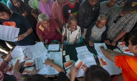 Sejumlah warga korban bencana antre untuk mendapatkan dana Jaminan Hidup (Jadup) yang mulai disalurkan di kompleks Hunian Sementara (Huntara) Desa Mpanau, Sigi, Sulawesi Tengah, Senin (1/7/2019). 