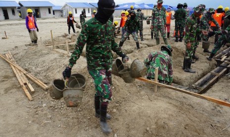 Personil TNI bersama sejumlah pekerja mengerjakan pembangunan hunian tetap (Huntap) bantuan Yayasan Budha Tzu Chi bagi korban bencana gempa, tsunami dan likuefaksi di Kelurahan Tondo, Palu, Sulawesi Tengah, Senin (1/7/2019).