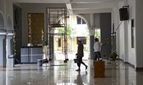 Petugas mengecat dinding masjid Al-Mabrur Asrama Haji Pondok Gede, Jakarta, Selasa (2/7/2019).