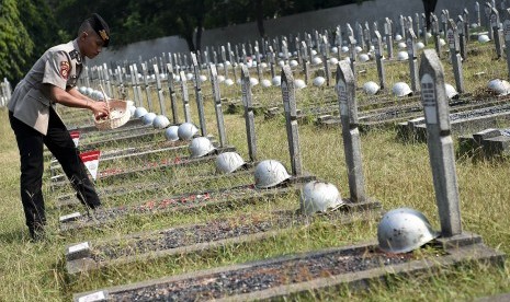 Anggota Polri menabur bunga saat upacara ziarah makam dan tabur bunga di Taman Makam Pahlawan Nasional Utama (TMPNU) Kalibata, Jakarta, Kamis (4/7/2019).