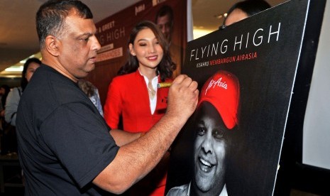 CEO AirAsia Group Tony Fernandes (kiri), menandatangani poster saat peluncuran bukunya yang berjudul Flying High: Kisahku Membangun AirAsia, di Jakarta, Kamis (4/7/2019).