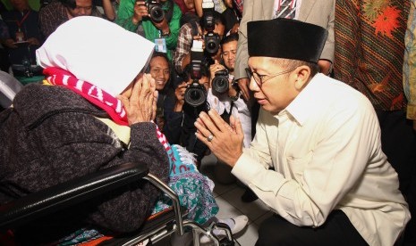 Menteri Agama Lukman Hakim Saifuddin (kanan) menyambut jamaah calon haji di asrama haji embarkasi Surabaya, Jawa Timur, Jumat (5/7/2019). 