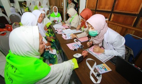 Petugas kesehatan memeriksa kesehatan jamaah calon haji (JCH) yang tergabung dalam kelompok terbang (kloter) I Embarkasi Banjarmasin sebelum memasuki Asrama haji Embarkasi Banjarmasin, Banjarbaru, Kalimantan Selatan, Senin (8/7/2019).