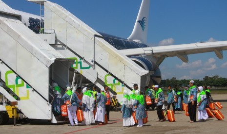 Tata Cara Sholat di Pesawat unutuk Jamaah Haji (2). Foto: Sejumlah jamaah calon haji asal Hulu Sungai Selatan dan Banjarmasin berjalan memasuki pesawat saat keberangkatan kloter pertama di Bandara Syamsuddin Noor, Banjarbaru, Kalimantan Selatan, Selasa (9/7/2019).