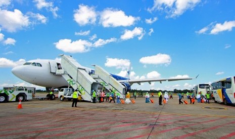 Sejumlah jamaah calon haji asal Hulu Sungai Selatan dan Banjarmasin berjalan memasuki pesawat saat keberangkatan kloter pertama di Bandara Syamsuddin Noor, Banjarbaru, Kalimantan Selatan, Selasa (9/7/2019). Calon Jamaah Haji Kalteng akan Berangkat 18 Juni dari Banjarmasin