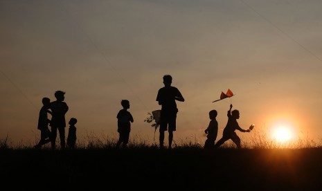 Sejumlah anak bermain layang-layang di persawahan Desa Undaan, Kudus, Jawa Tengah, Rabu (10/7/2019).