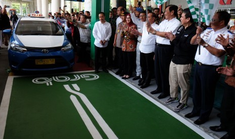 Menko Bidang Kemaritiman Luhut Binsar Panjaitan (ketiga kanan) bersama Presiden Grab Indonesia Ridzki Kramadibrata (kedua kanan) Dirjen Perhubungan Darat Kementerian Perhubungan Budi Setiadi (kanan) Gubernur Sumut Edy Rahmayadi (keempat kanan) melepas rombongan taksi pada peluncuran 'GrabCar Airport' di Bandara Internasional Kualanamu, Deli Serdang, Sumatera Utara, Kamis (11/7/2019).