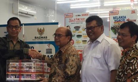 Penyerahan simbolis peluncuran kerja sama Baznas dengan Alfamart oleh General Manager Corporate Communication Alfamart, Nur Rochman, kepada Ketua Baznas, Bambang Sudibyo, dilakukan di Gerai Alfamart Menteng, Jakarta Pusat, Jumat (12/7) disaksikan juga oleh Direktur Bisnis PT Artajasa Pembayaran Elektronis, Anthoni Morris, dan Direktur Utama Baznas, Arifin Purwakananta