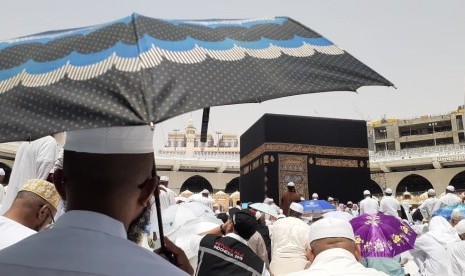 Seorang jamaah calon haji menunggu dimulainya Shalat Jumat di Masjid Al Haram, Jumat (12/7). Penggunaan payung untuk jamaah haji memang dianjurkan karena cuaca di Kota Makkah pada siang hari bisa mencapai 42 derajat celcius. 