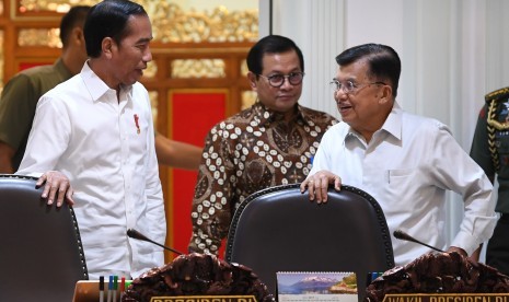 Presiden Joko Widodo (kiri) berbincang dengan Wakil Presiden Jusuf Kalla (kanan) dan Seskab Pramono Anung sebelum memimpin rapat terbatas di Kantor Presiden Jakarta, Senin (15/7/2019).