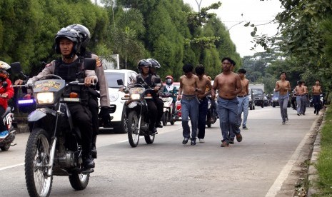 Polisi menghukum sejumlah pelajar yang diduga terlibat tawuran dengan berlari di Simpang Sentul, Bogor, Jawa Barat.