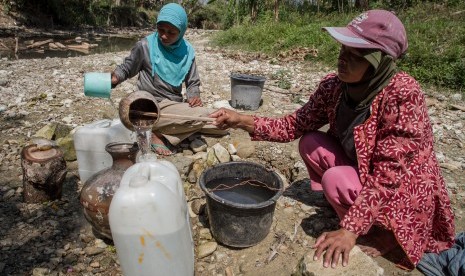 Warga mengambil air dari lubang yang digali di dasar sungai yang kering di Desa Glagah, Tangen, Sragen, Jawa Tengah, Selasa (16/7/2019).