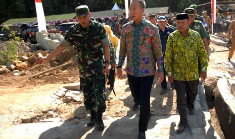 Menteri Sosial Agus Gumiwang Kartasasmita (tengah) didampingi Letkol Inf Andriyanto (kiri) meninjau pembangunan jalan dari program TNI Manunggal Membangun Desa (TMMD) usai penyerahan bantuan di Kecamatan Biringkanayya, Makassar, Sulawesi Selatan, Selasa (16/7/2019). 