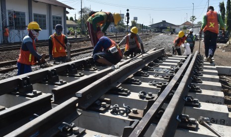 Pekerja memasang rel dalam proyek jalur ganda kereta lintas selatan di kawasan Stasiun KA Madiun, Jawa Timur (ilustrasi).