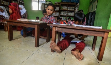 Siswa kelas dua Sekolah Dasar Negeri (SDN) Cikadongdong mengikuti Kegiatan Belajar Mengajar (KBM) di lantai ruang perpustakaan di Singaparna, Kabupaten Tasikmalaya, Jawa Barat, Rabu (17/7/2018).