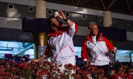 Menpora Imam Nahrawi (kiri) dan Gubernur Jawa Tengah Ganjar Pranowo (kanan) bersiap memukul kok pada pembukaan ASEAN Schools Games XI Tahun 2019 di Holy Stadium Terang Bangsa School, Semarang, Jawa Tengah, Kamis (18/7/2019).