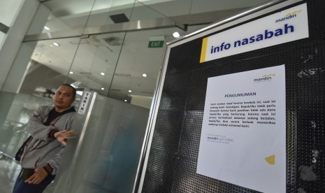 Seorang nasabah keluar dari kantor usai melakukan pengaduan berkurangnya saldo rekening mereka di kantor Bank Mandiri Mataram, NTB, Sabtu (20/7/2019).