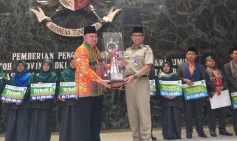 Gubernur DKI Jakarta Anies Rasyid Baswedan menyerahkan langsung bonus dan penghargaan Pemprov DKI Jakarta kepada para juara dari kafilah Ibu Kota dalam kompetisi STQH XXV, Balai Kota, Senin (22/7). 