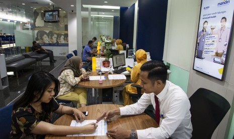 Pegawai melayani nasabah di Bank Mandiri, Jakarta, Senin (22/7/2019).