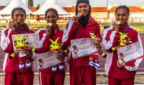 Tim pelari Indonesia Daniela Elim (kanan), Diva Aprilian (kedua kanan), Erna Nuryanti (kedua kiri) dan Raden Roselin (kiri) berfoto dengan medali emas usai penyerahan medali final Lari Estafet 4x100 meter Putri Atletik ASEAN Schools Games ke-11 Tahun 2019 di GOR Tri Lomba Juang, Semarang, Jawa Tengah, Senin (22/7/2019). 