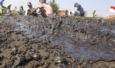 Warga mengumpulkan limbah tumpahan minyak 'Oil Spill' yang tercecer milik Pertamina di Pesisir Pantai Cemarajaya, Karawang, Jawa Barat, Rabu (24/7/2019).