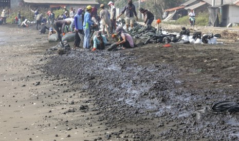 Warga mengumpulkan limbah tumpahan minyak 'Oil Spill' yang tercecer milik Pertamina di Pesisir Pantai Cemarajaya, Karawang, Jawa Barat, Rabu (24/7/2019).