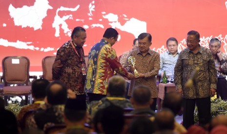 Wakil Presiden Jusuf Kalla (kedua kanan) didampingi Gubernur Bank Indonesia Perry Warjiyo (kiri) dan Menteri Perekonomian Darmin Nasution (kanan) memberikan penghargaan Tim Pengendalian Inflasi Daerah (TPID) 2018 Provinsi Terbaik 2018 kepada Gubernur DKI Jakarta Anies Baswedan (kedua kiri) saat Rapat Koordinasi Nasional Pengendalian Inflasi 2019 di Jakarta, Kamis (25/7/2019).