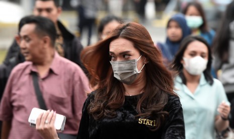 Sejumlah pejalan kaki menggunakan masker ketika melintas di kawasan Jalan Jenderal Sudirman, Jakarta, Kamis (25/7/2019).