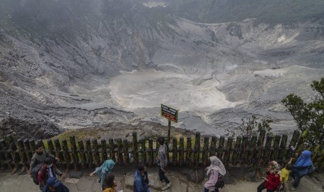 Wisatawan menikmati pemandangan kawah Gunung Tangkuban Parahu di Kabupaten Bandung Barat, Jawa Barat, Senin (25/12). Pengelola wisata Gunung Tangkuban Perahu mencatat sekitar 7 ribu wisatawan lokal maupun asing berkunjung ke Tangkuban Parahu pada hari libur Natal.