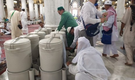  40.000 Ton Air Zamzam Didistribusikan ke Waduk Masjid Nabawi. Foto:  Sejumlah jamaah haji meminum air zamzam di Masjid Nabawi, Madinah, Sabtu (27/7). Sebagian jamaah membawa air zamzam ke pemondokannya untuk diminum di kamar. 