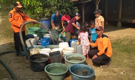 Petugas BPBD Karawang, saat mendistribusikan air bersih bagi warga yang terdampak kekeringan, salah satunya di Kecamatan Tegalwaru. 