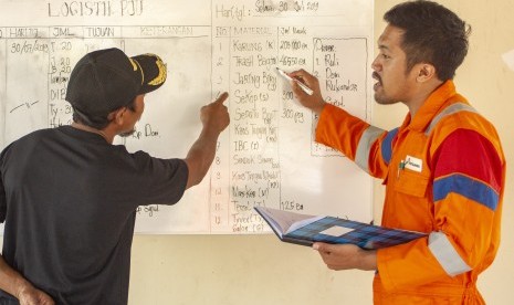 Petugas menjelaskan data logistik yang dikirim untuk penanganan area yang tercemar tumpahan minyak mentah kepada perwakilan warga di Posko Logistik PHE ONWJ, Pusakajaya Utara, Karawang, Jawa Barat, Selasa (30/7/2019).