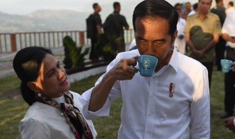 Presiden Joko Widodo (kanan) didampingi Ibu Negara Iriana Joko Widodo mencoba kopi lokal jenis Lintong Arabica saat mengunjungi kawasan Sipinsur Geosite di Kabupaten Humbang Hasundutan (Humbahas), Sumatera Utara, Senin (29/7/2019).