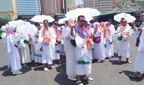 Jamaah haji menggunakan payung akibat cuaca yang sangat terik di Pos Terminak Syib Amir  Makkah, Senin (5/8).  Cuaca di Makkah pada siang hari mencapai 41 derajat Celsius dan malam 33 derajat Celsius 