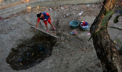 Warga mengambil air rembesan dari kubangan sungai yang mengering untuk kebutuhan mencuci dan mandi di Desa Marmoyo, Kecamatan Kabuh, Kabupaten Jombang, Jawa Timur, Selasa (6/8/2019).